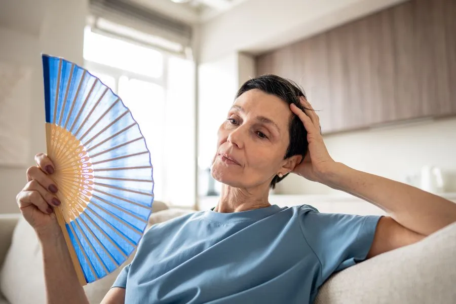 woman on the couch fanning herself